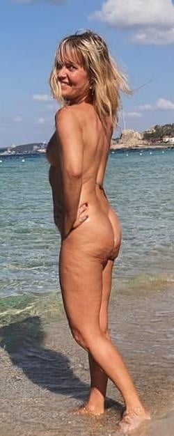 Amateur: Alessia: A Mature MILF’s Beachside Nudity A mature MILF, Alessia, stands nude on a beach, her athletic build and natural beauty on full display, exuding confidence and power.